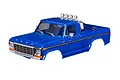 A blue Traxxas 1/18 1979 Ford F-150 RC truck body shell with chrome roll bar and lights, isolated on a white background.