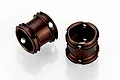 Two dark bronze-coloured cylindrical RC driveshaft couplings with small holes, isolated on a white background.