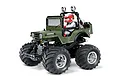 Tamiya Wild Willy 2 RC monster truck kit, an olive green military-style jeep with a driver figure, oversized black tires, and chrome wheels on a white background.