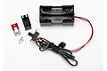 Traxxas AA battery holder with an integrated power switch, including mounting hardware and a faceplate on a white background.