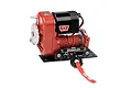 RC4WD 1/10 scale Warn 8274 winch with red housing, black motor, and red winch line on a black mounting plate.