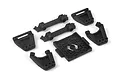 A set of black plastic RC car parts including shock towers, chassis braces, and a mounting plate on a white background.