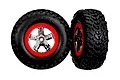 Two Traxxas 2.2/3.0 inch off-road RC tires mounted on red and chrome five-spoke wheels against a white background.