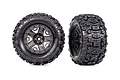 Two Traxxas 2.8 inch Sledgehammer RC monster truck tires pre-mounted on grey chrome wheels, shown from front and side angles.