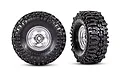 Two Traxxas 1.0 inch Mickey Thompson Baja Pro XS crawler tires mounted on satin chrome 6-spoke rims, shown from front and side angles.
