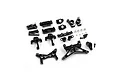 A collection of black anodized aluminium RC car upgrade parts including suspension arms, shock towers, and hardware on a white background.