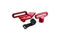A set of red anodized aluminium RC battery mounts and a black velcro strap on a white background.