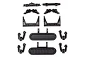 A collection of black plastic RC car spare parts including shock towers, bumper mounts, and suspension components arranged on a white background.