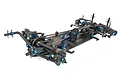 A high-angle studio shot of a Team Associated TC8 1/10 scale electric RC touring car chassis kit, featuring a carbon fiber deck and blue anodized aluminum parts.