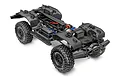 A high-angle studio shot of a Traxxas TRX-4 RC rock crawler chassis kit, showing the black frame, large off-road tires, and internal components.