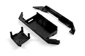 A set of black plastic RC chassis parts including a main battery tray and support components on a white background.