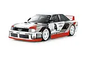 A studio shot of a Tamiya Audi 90 Quattro RC touring car model, featuring a white, red, and grey racing livery with number 4 decals.