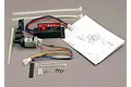 Traxxas EZ-Start system kit including the starter motor unit, control box, wiring, zip ties, screws, and an instruction manual on a grey surface.