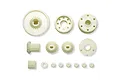 A collection of various off-white plastic RC car gears and small components arranged on a white background.