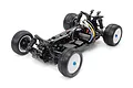 A high-angle studio shot of a Tamiya DB01SR 1/10 scale 4WD RC buggy chassis, showing the black frame, suspension, motor, and off-road tires.