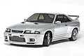 A silver Tamiya Nissan Skyline GT-R R33 RC drift car model on a white background.