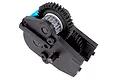 A black plastic RC truck gearbox assembly with exposed gears and a blue metal motor mount component on a white background.