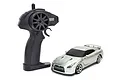 A silver Kyosho First Mini-Z Nissan GT-R R35 RC car next to its black pistol-grip radio transmitter on a white background.