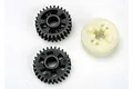 Two black plastic gears and one off-white plastic gear component for a Traxxas RC gearbox.