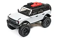 Axial SCX24 2021 Ford Bronco RC rock crawler in grey, featuring a black roof, roof rack with accessories, and off-road tires on a white background.