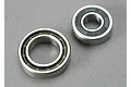 Two metal ball bearings of different sizes sitting on a grey surface.