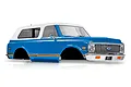 A blue and white pre-painted 1972 Chevrolet Blazer RC body shell for the Traxxas TRX-4, featuring a chrome grille and wood-grain side trim.