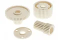 A set of four off-white plastic RC car gears and a spacer plate on a white background.