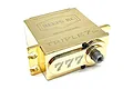 A gold-coloured Reefs RC TRIPLE7 14V brushless metal gear servo with a polished brass finish, shown from a high-angle studio perspective.