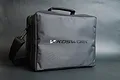 A black Koswork transmitter bag with a shoulder strap, shown against a dark grey background.