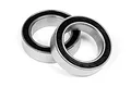 Two metal ball bearings with black rubber seals resting on a white background.