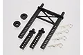 A Traxxas rear body mount set including a black plastic mount frame, two smaller posts, two washers, and four metal body clips on a white background.