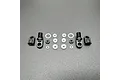 A set of RC shock rebuild components including two threaded shock caps, two rod ends, and various O-rings and spacers laid out on a grey surface.