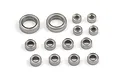 A collection of fourteen metal shielded ball bearings of varying sizes arranged on a white background.
