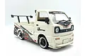 A white WPL D14S Suzuki Carry RC drift truck with a wide body kit, rear spoiler, and custom decals on a white background.