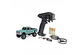 Axial SCX30 Chevrolet K10 RC rock crawler in green, including a Spektrum transmitter, four AA batteries, a LiPo battery, and a USB charger.