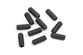 A collection of ten black metal grub screws scattered on a white background.
