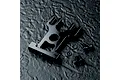 A black aluminium motor mount for an RC car, shown with four small black screws and two washers on a dark textured surface.