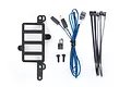 Traxxas Pro Scale lighting components including a black plastic mount, LED lights with wiring, zip ties, and small screws on a white background.