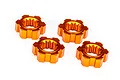 Four orange anodized aluminium wheel hexes for Traxxas RC vehicles arranged on a white background.