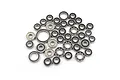 A collection of various sized steel ball bearings scattered on a plain white background.