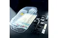 MST 1/10 scale clear polycarbonate Evo V RC car body shell with included plastic parts, decals, and accessories on a black background.