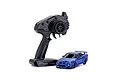 Kyosho Mini-Z Nissan Skyline GT-R R34 RC car in metallic blue next to a black Syncro KT-531P radio transmitter on a white background.