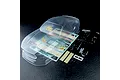 An unpainted clear polycarbonate RC car body shell with included decal sheet, plastic parts tree, and mounting hardware on a black background.