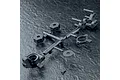 A black plastic parts tree containing RC car wheel hexes, steering hubs, and washers on a textured dark surface.