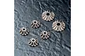 A set of six metal differential bevel gears of varying sizes arranged on a dark textured surface.