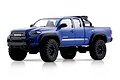 Studio product photo of a blue FMS FCX24M Toyota Tacoma RC rock crawler truck on a white background.