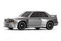 Studio product photo of a grey 1989 BMW M3 RC drift car viewed from a front three-quarter angle against a plain white background.