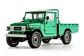 Studio shot of the FMS Toyota FJ45 RC rock crawler in green with a white roof and flatbed.