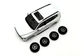 Kyosho Mini-Z Toyota Land Cruiser 300 white painted body shell viewed from above alongside four matching tires and wheels on a plain white background.