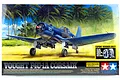 Tamiya 1/32 scale Vought F4U-1A Corsair model kit box art featuring a blue fighter plane on a tropical beach.